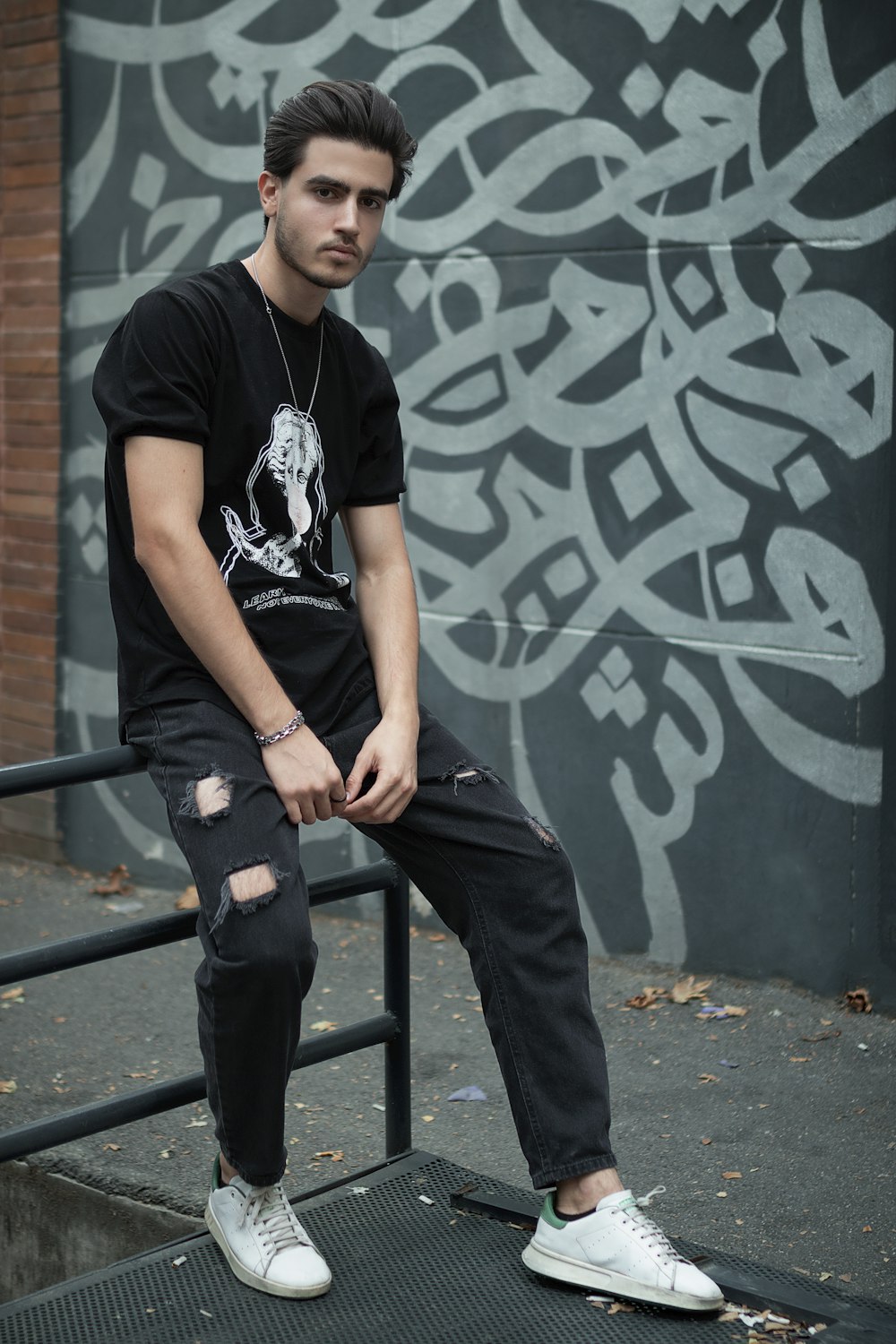 a young man sitting on a metal rail