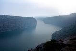 A serene mist rising over rugged canyon cliffs at dawn.