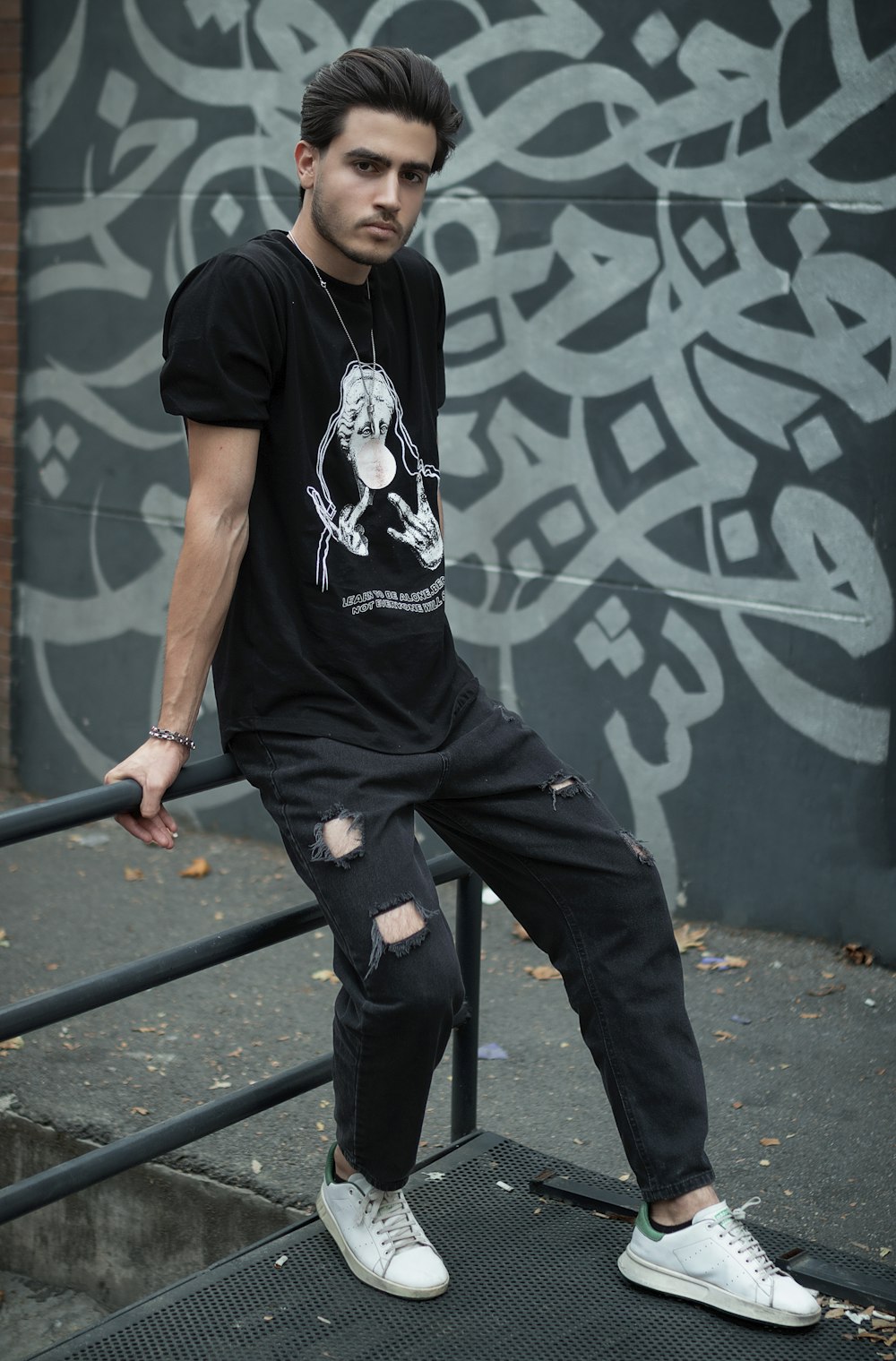 a man sitting on top of a metal rail