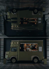 A sleek, modern food truck with a coffee and pastry menu parked by a city park.