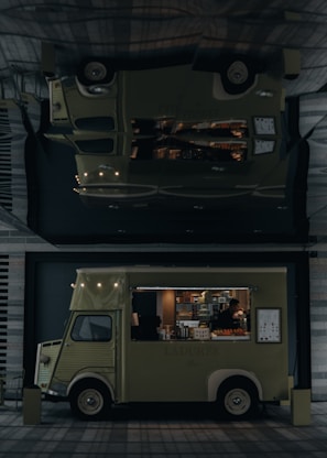 A vintage-style food truck with a pale green color is parked in an urban setting, offering a variety of pastries and beverages. The truck's interior is illuminated, highlighting pastries displayed inside. A person inside the truck is attending to the offerings or setting up. The truck bears the name 'LADUREE' on its side. Its exterior design features classic elements, and a menu board is visible.