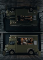 A vintage-style food truck with a pale green color is parked in an urban setting, offering a variety of pastries and beverages. The truck's interior is illuminated, highlighting pastries displayed inside. A person inside the truck is attending to the offerings or setting up. The truck bears the name 'LADUREE' on its side. Its exterior design features classic elements, and a menu board is visible.