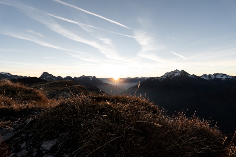 the sun is setting over a mountain range