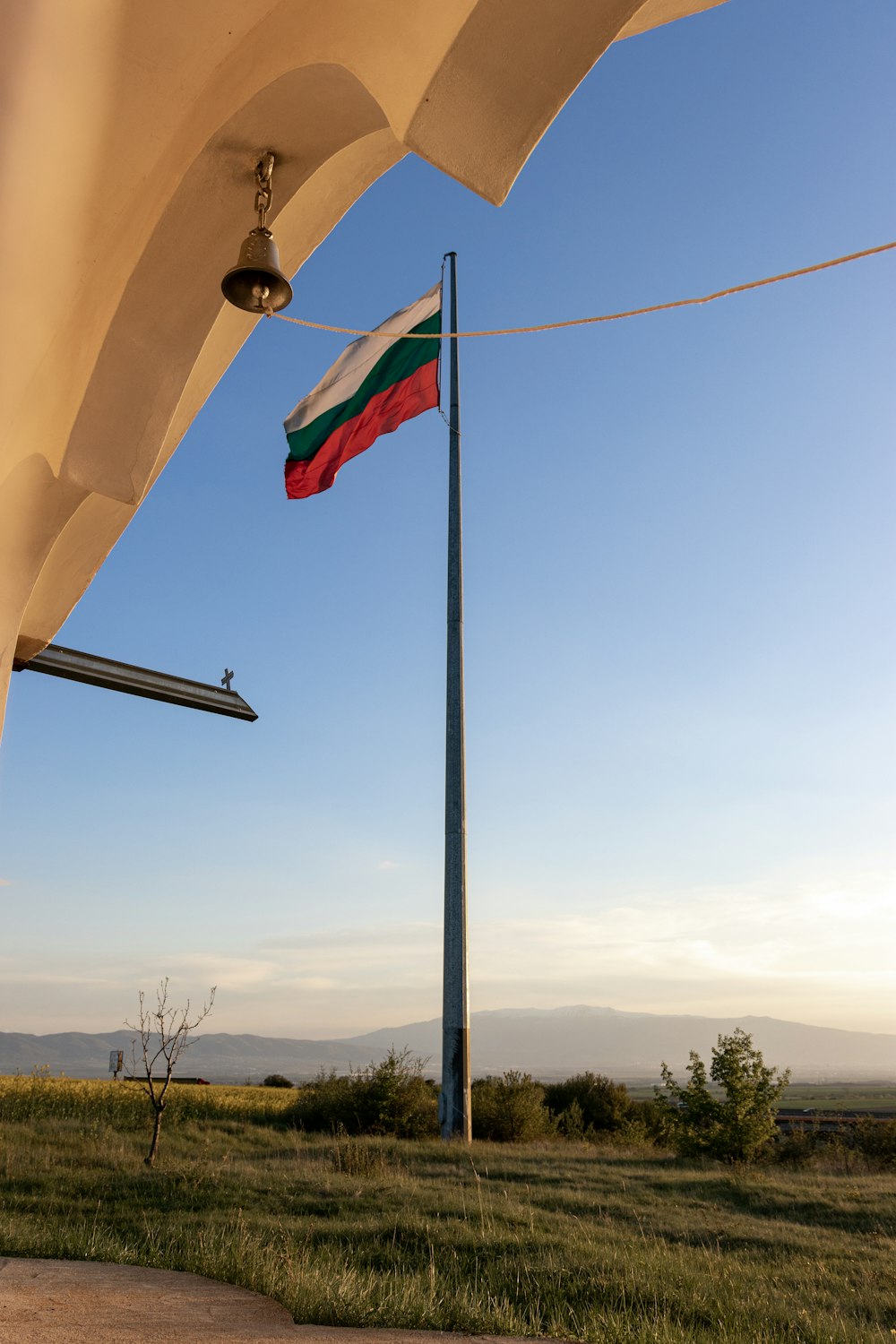 una bandera en un poste junto a un poste de luz