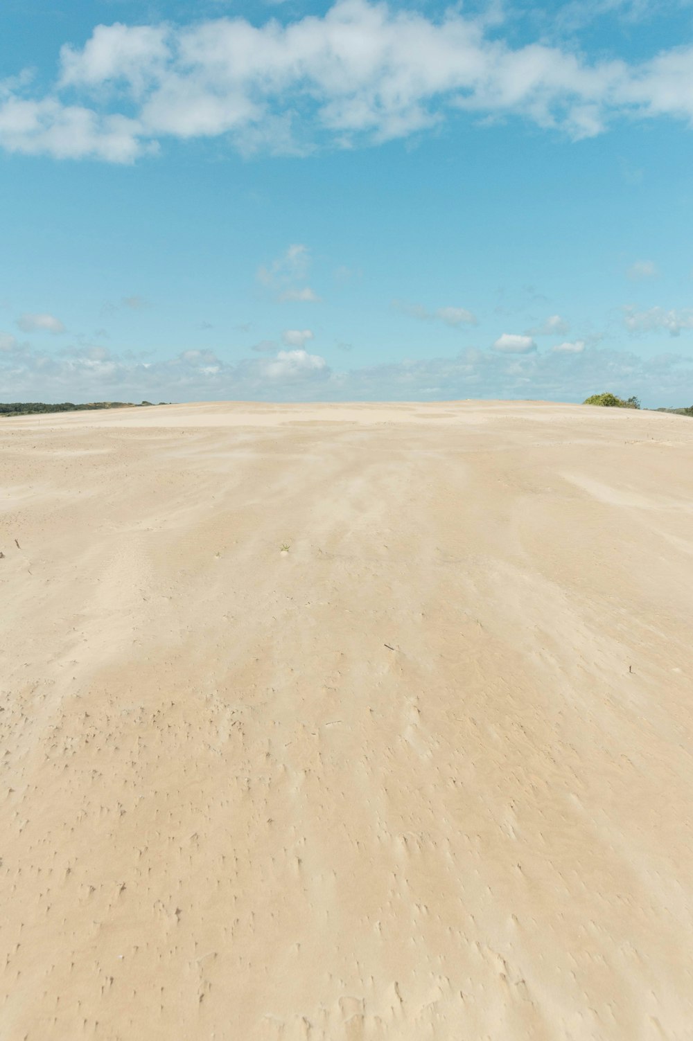 a large sandy area with a few clouds in the sky