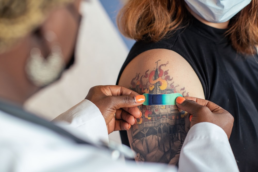 a woman with a tattoo on her back holding a cup