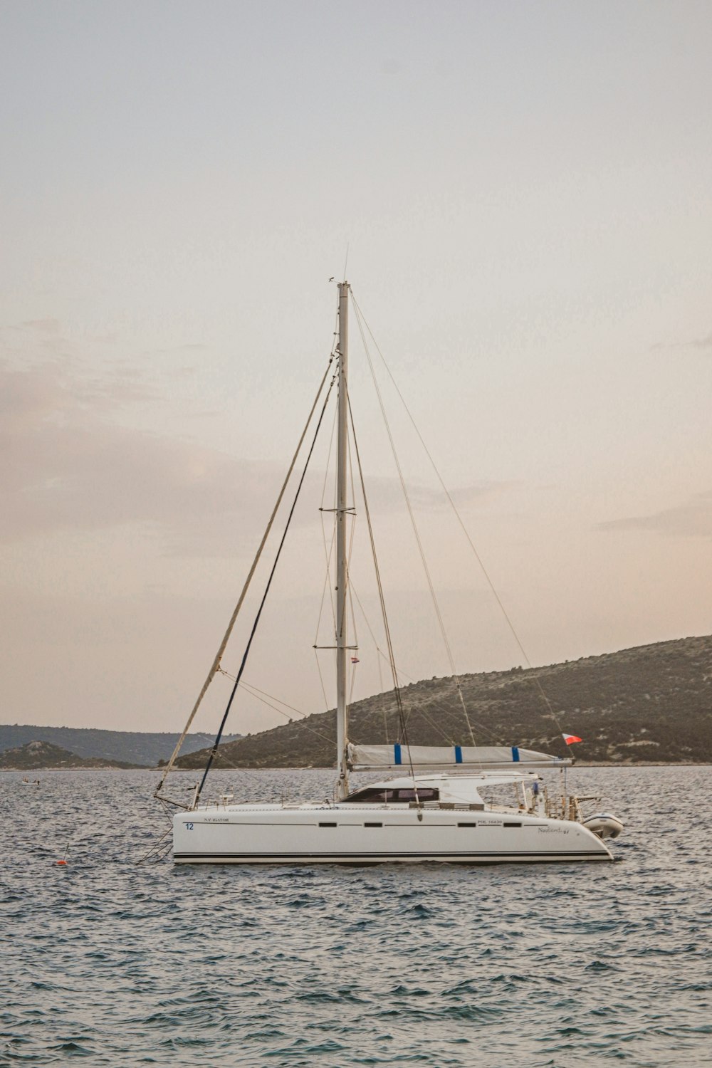 a sailboat floating in the ocean at sunset