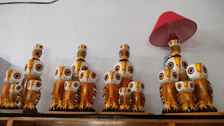 A colorful collection of cuddly owls perched on a wooden shelf in a child's room.