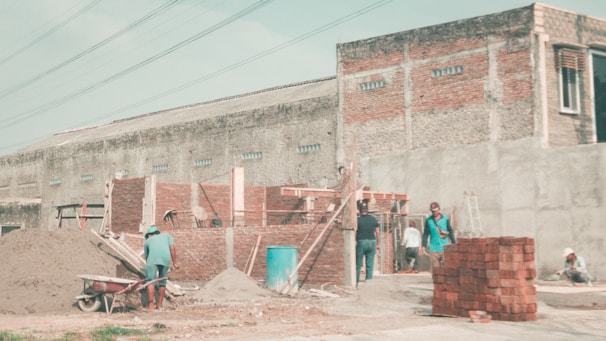 Construction site showing bricklayers installing Haraprasad Enterprise bricks on a residential building