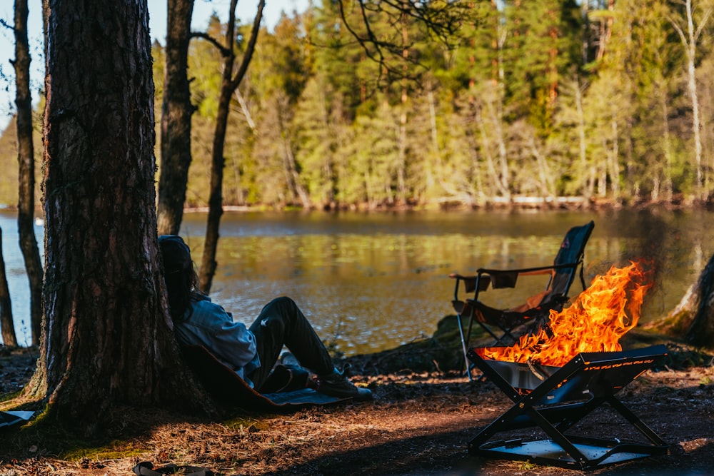 a man sitting in a chair next to a fire