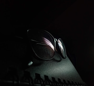 a pair of glasses sitting on top of a computer keyboard
