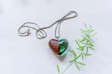 An elegant resin pendant with a single lavender sprig, resting on a wooden table.