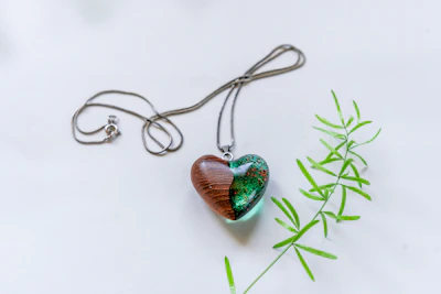 An elegant resin pendant with a single lavender sprig, resting on a wooden table.