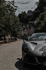 A sleek European sedan parked on a cobblestone street in a quaint town.