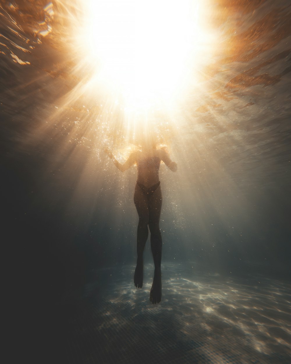 a person standing under the sun in the water