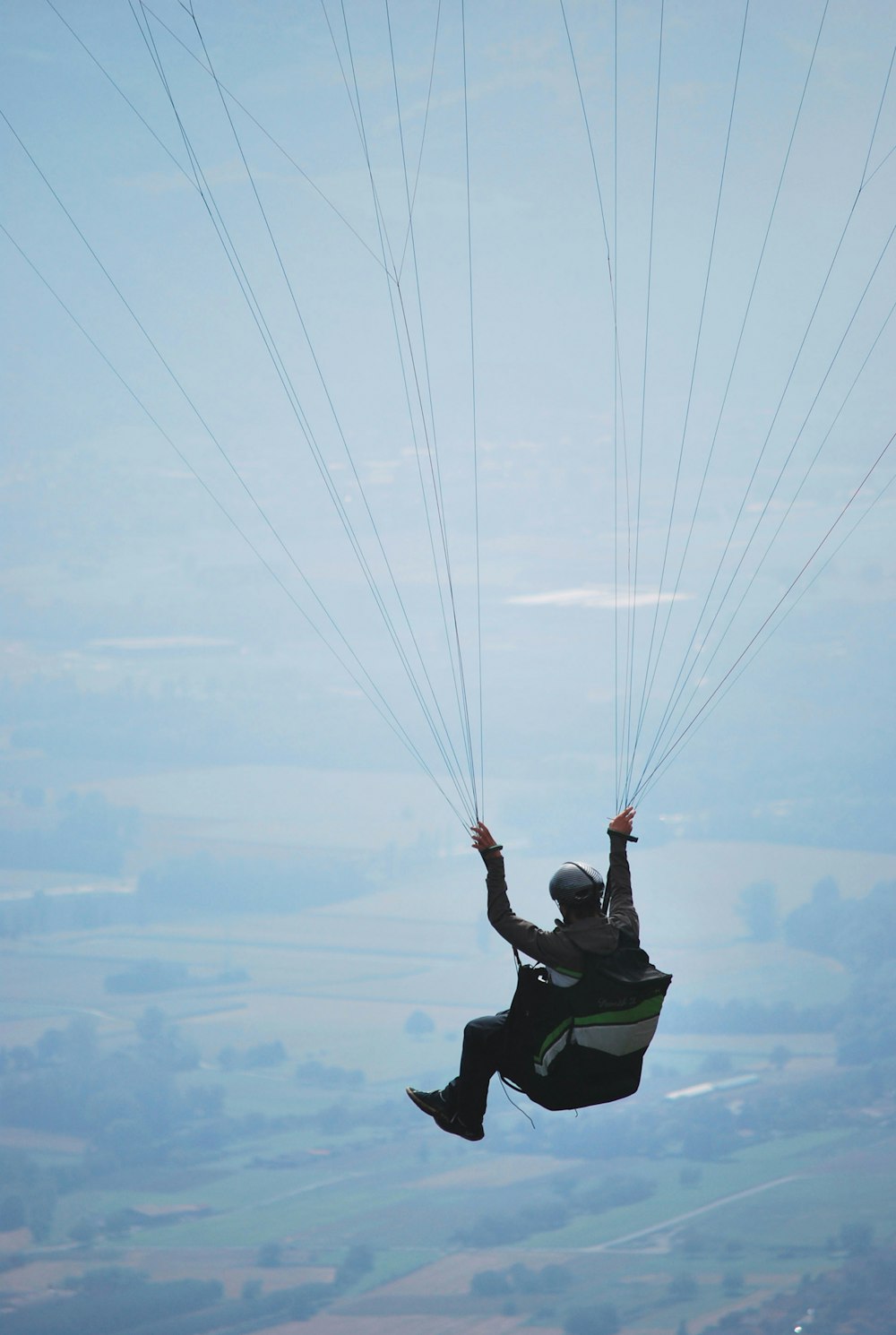 a man flying through the air on top of a parachute