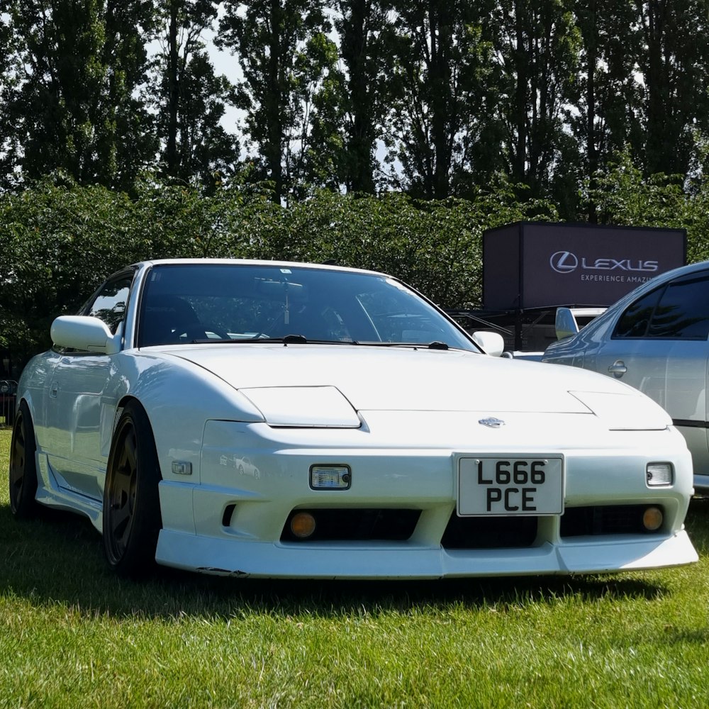 a white sports car parked next to a silver sports car