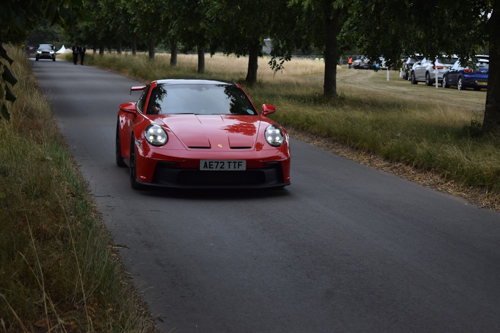 a red sports car driving down a road