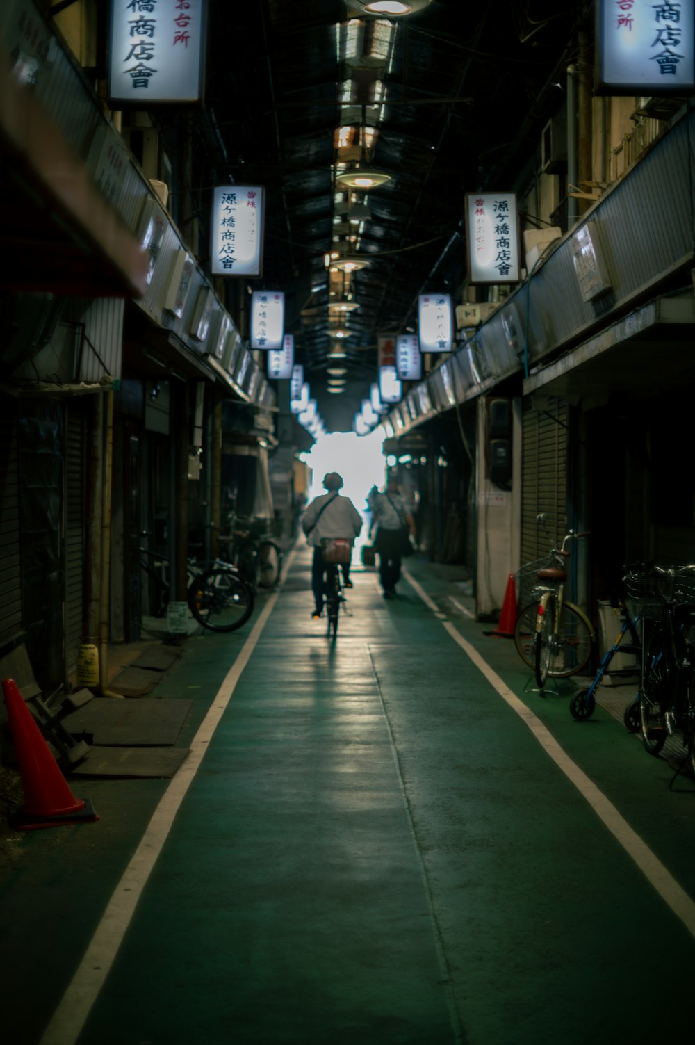 a man riding a bike down a narrow alley way