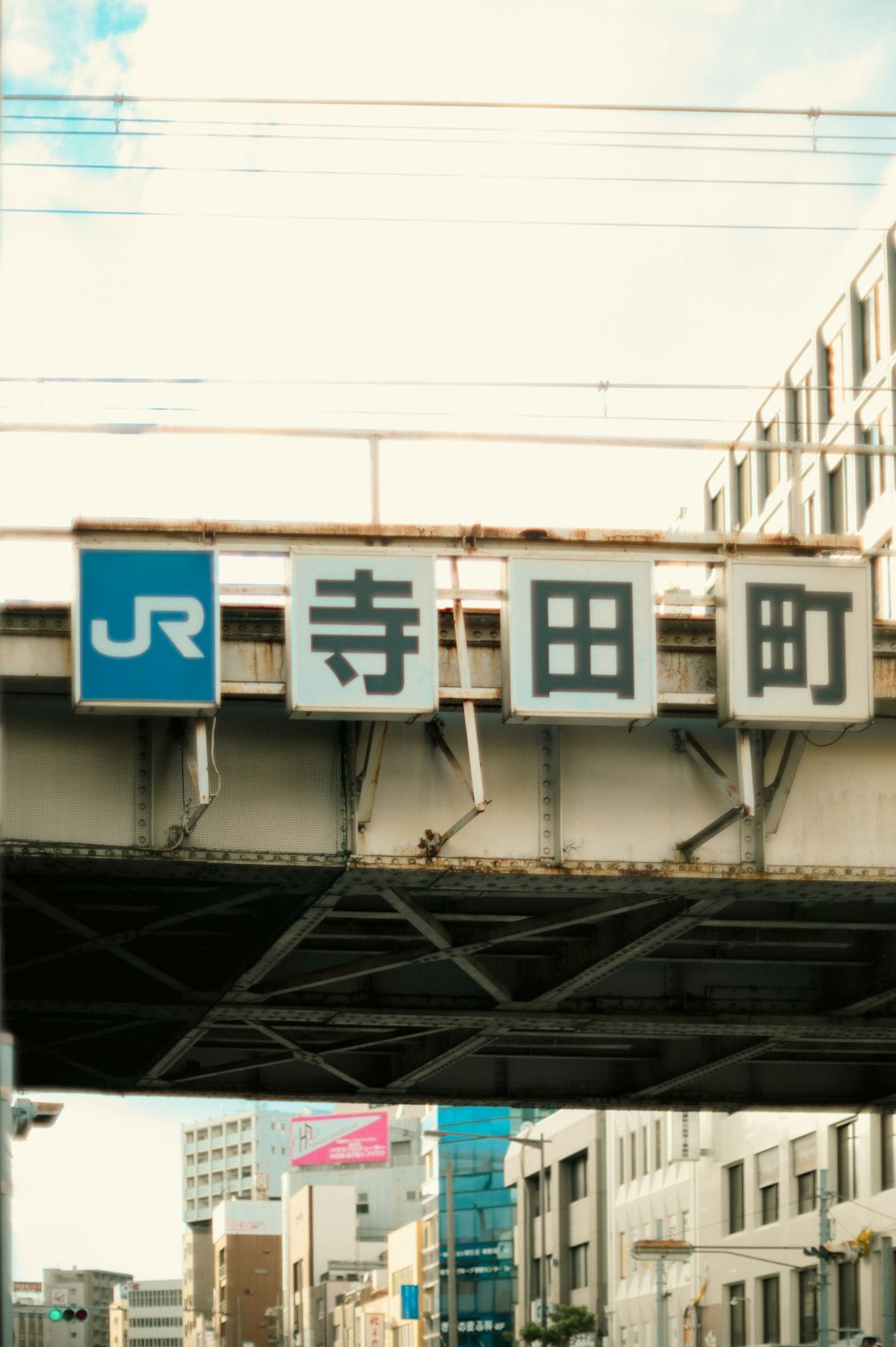 Eine Brücke über eine Stadtstraße mit asiatischen Schriftzeichen darauf