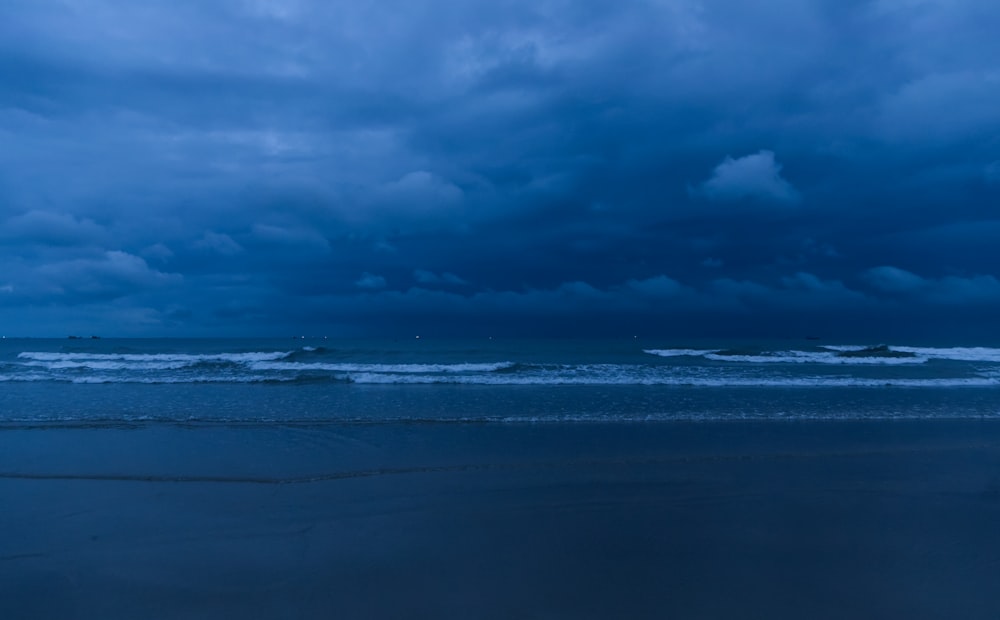 un ciel nuageux au-dessus de l’océan avec des vagues qui arrivent