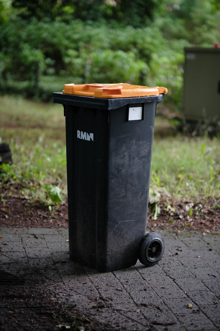 A single black residential trash can on the curb