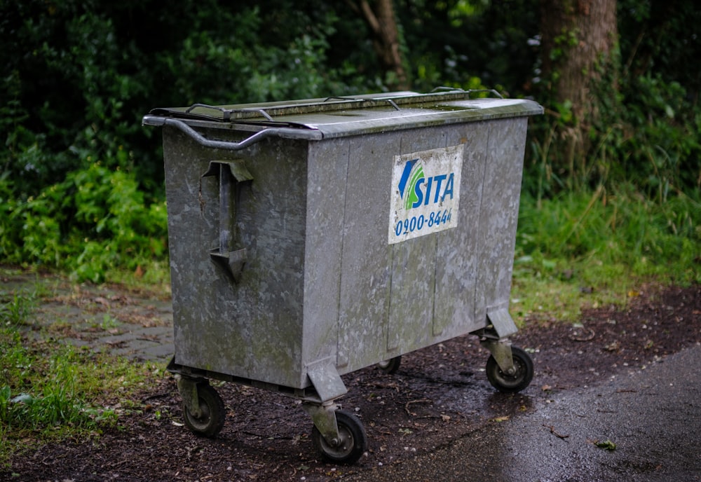 a trash can sitting on the side of a road