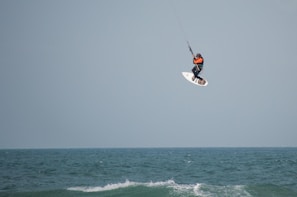 Close-up of kite control hands during a private lesson, wind rippling the water