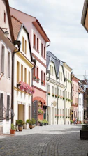 A quaint European village street lined with colorful houses and cobblestones.