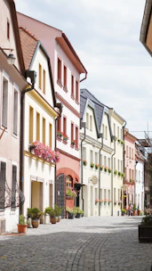 A quaint European village street lined with colorful houses and cobblestones.