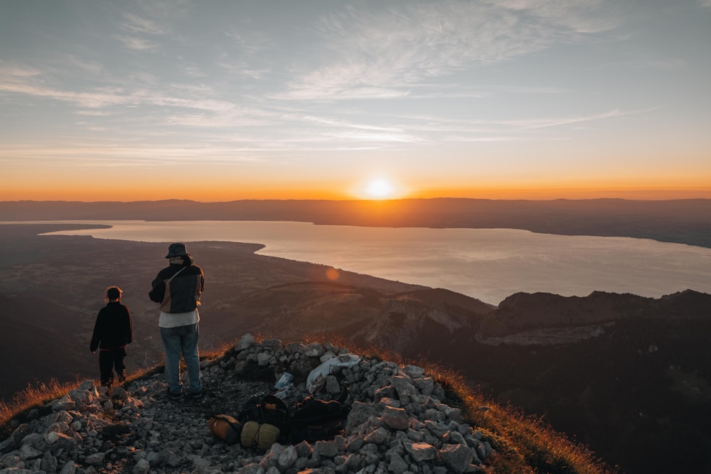 a couple of people standing on top of a mountain