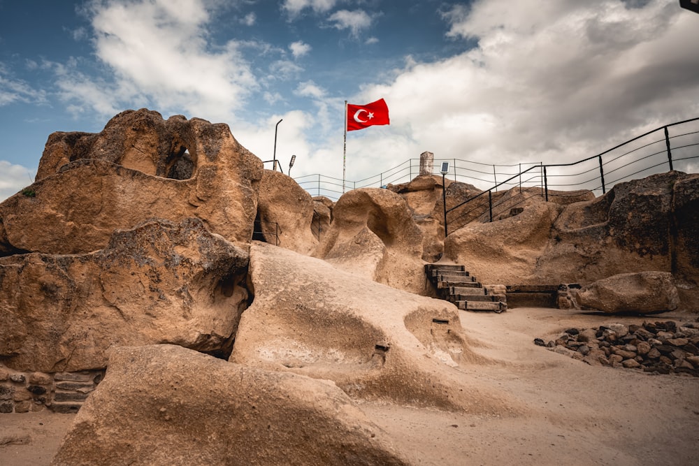 a red flag flying over a rocky area