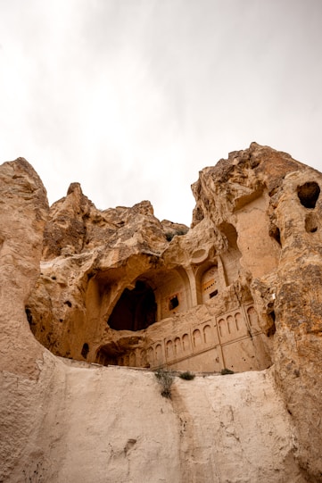 a rock formation with a building built into it, Cappadocia