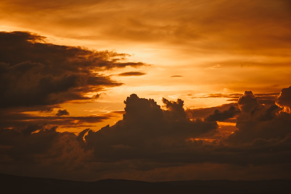 a plane flying in the sky at sunset