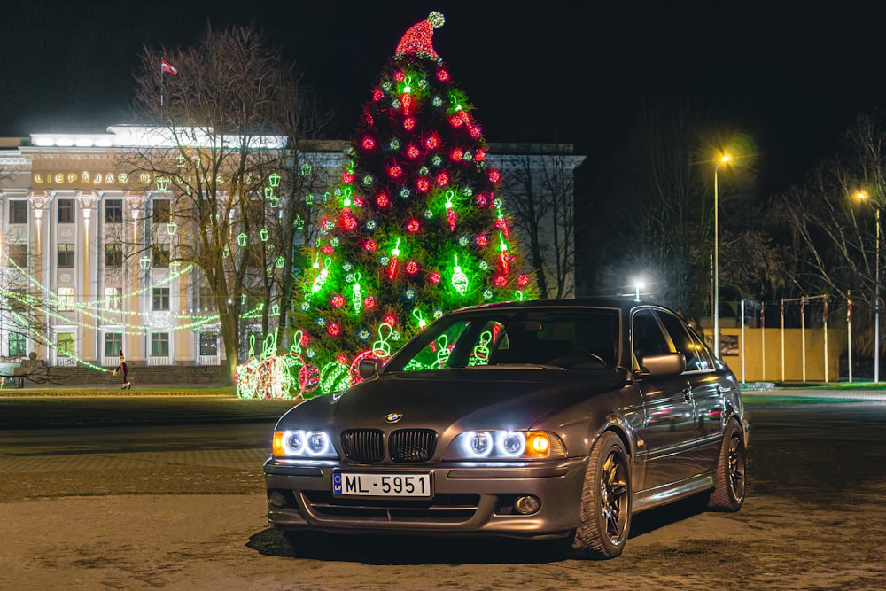a car parked in front of a christmas tree