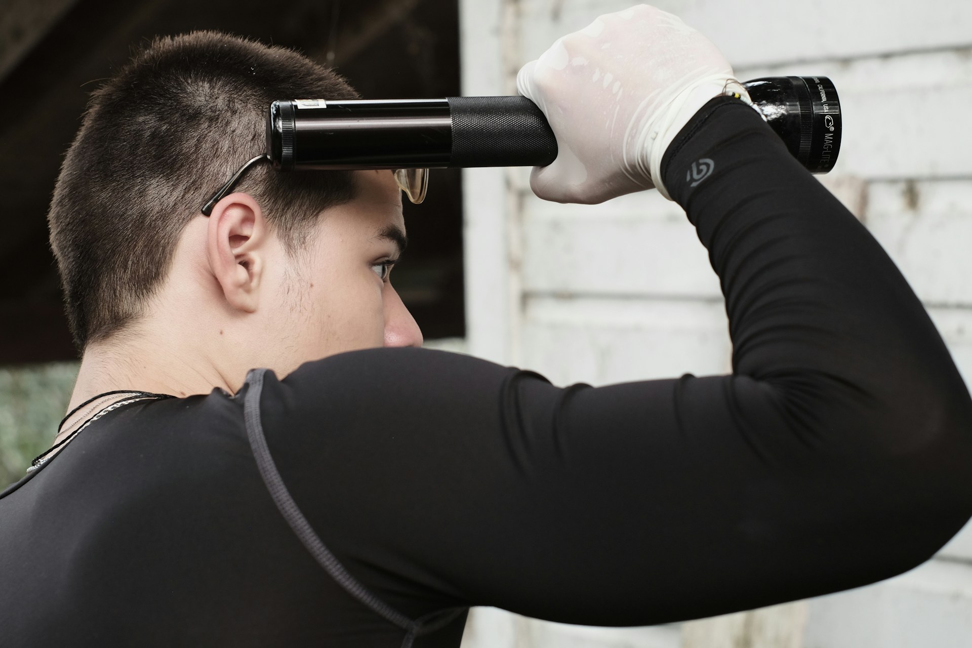 a man in a wet suit holding a hair dryer on his head