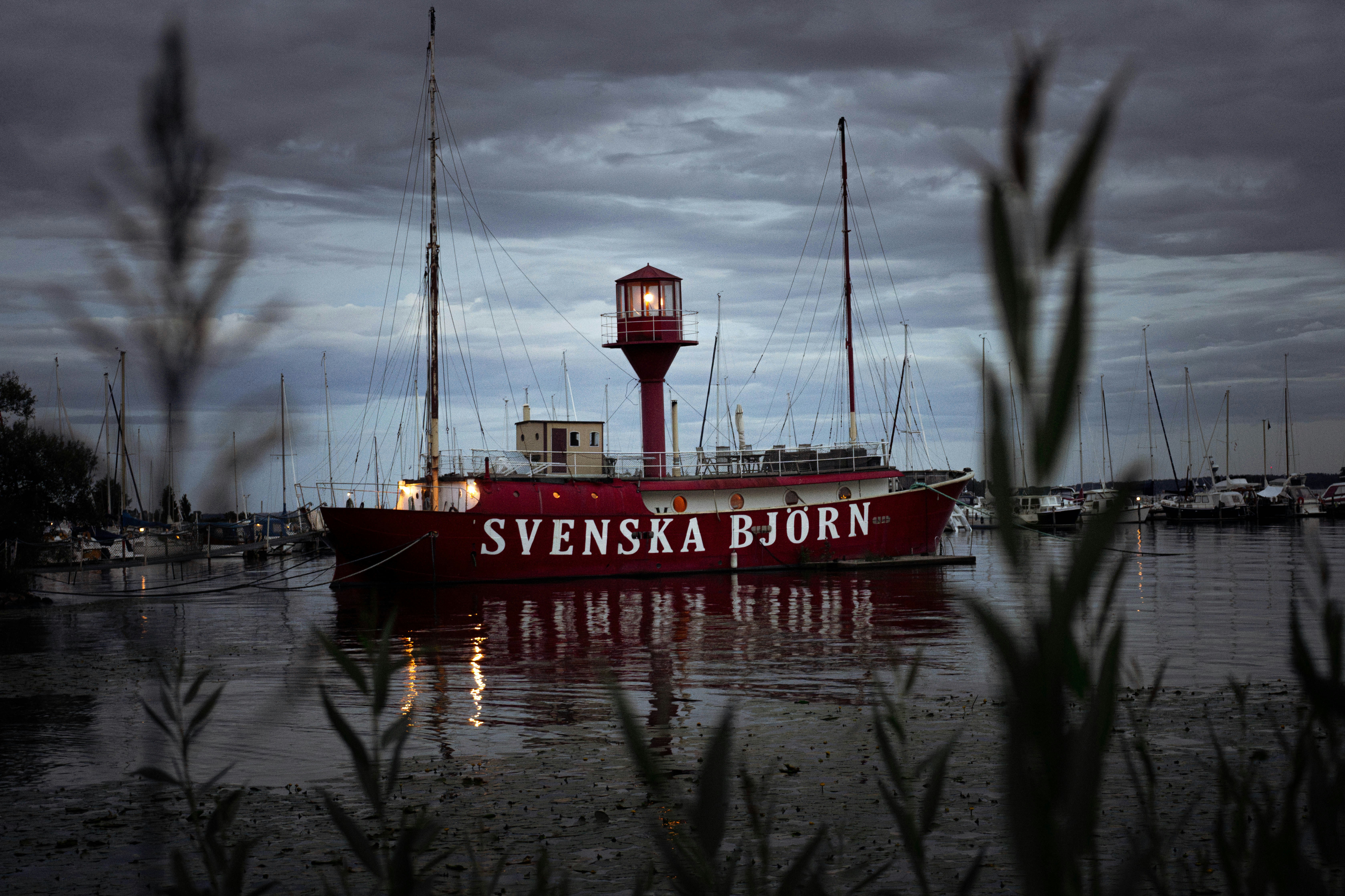 a large red boat floating on top of a body of water