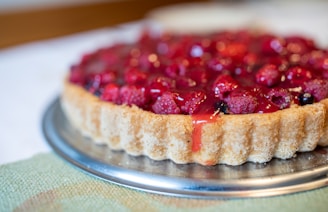a tart with raspberries on top of it
