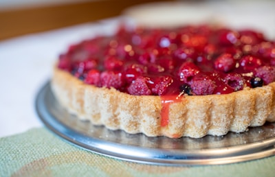 a tart with raspberries on top of it