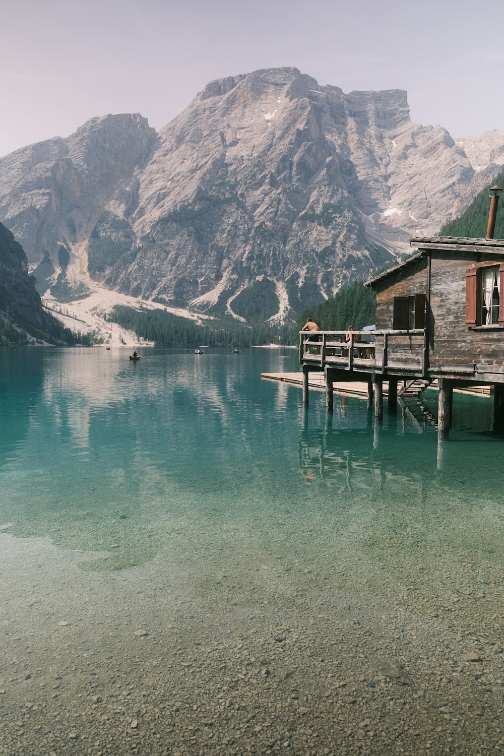a wooden dock sitting next to a mountain lake