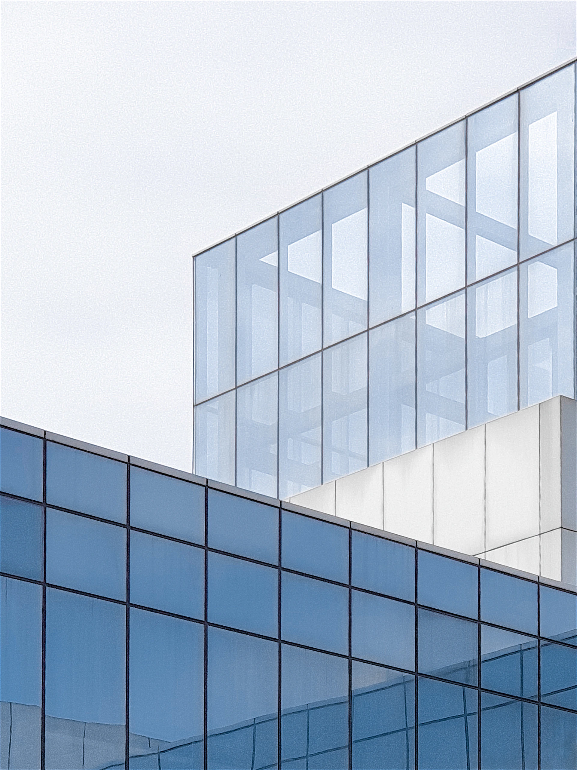 an airplane is flying over a glass building