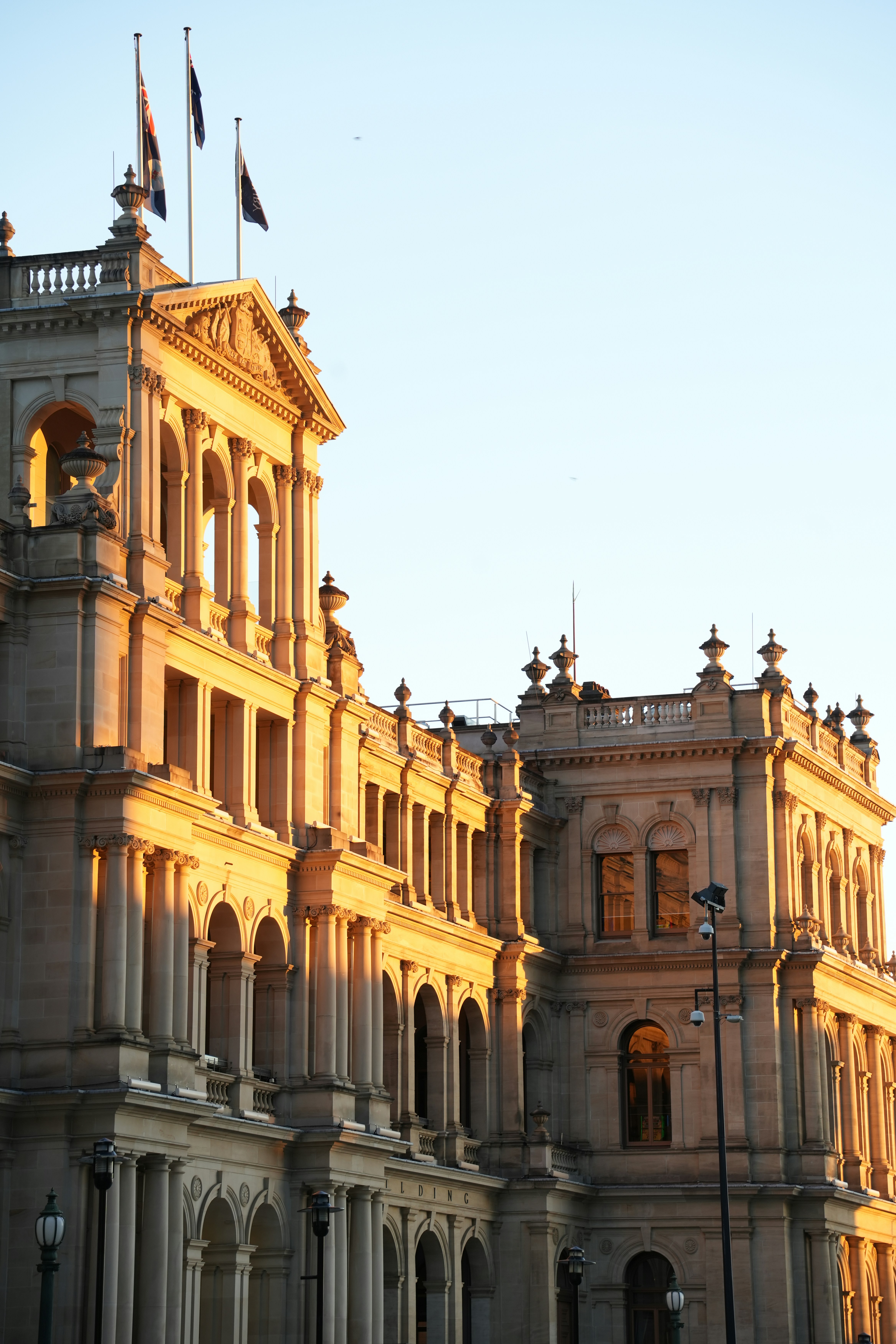 Historic Indian industrial building with warm amber stone walls, bright daylight, architectural grandeur