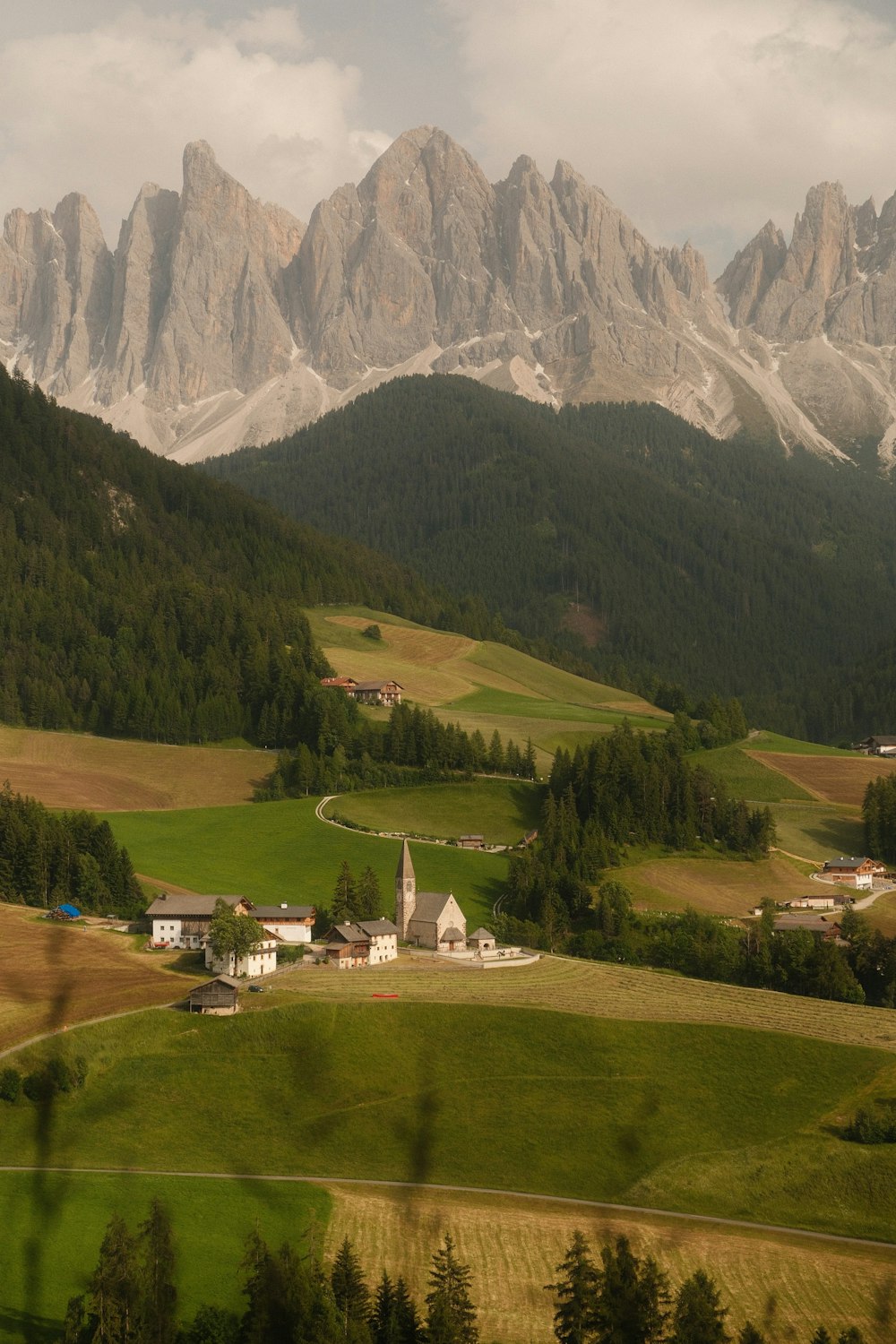 a view of a mountain range with a church in the foreground