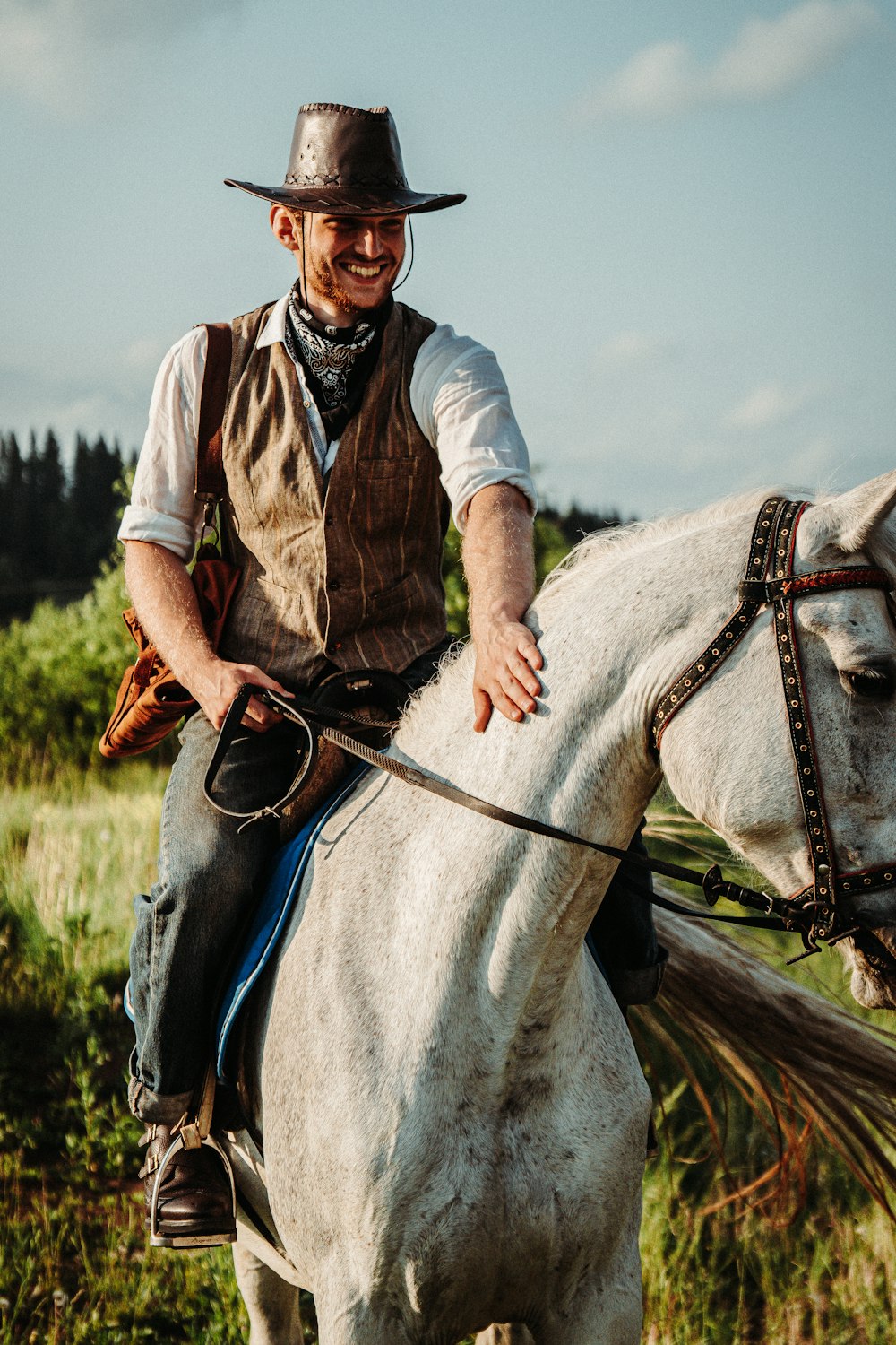 a man in a cowboy hat riding a white horse