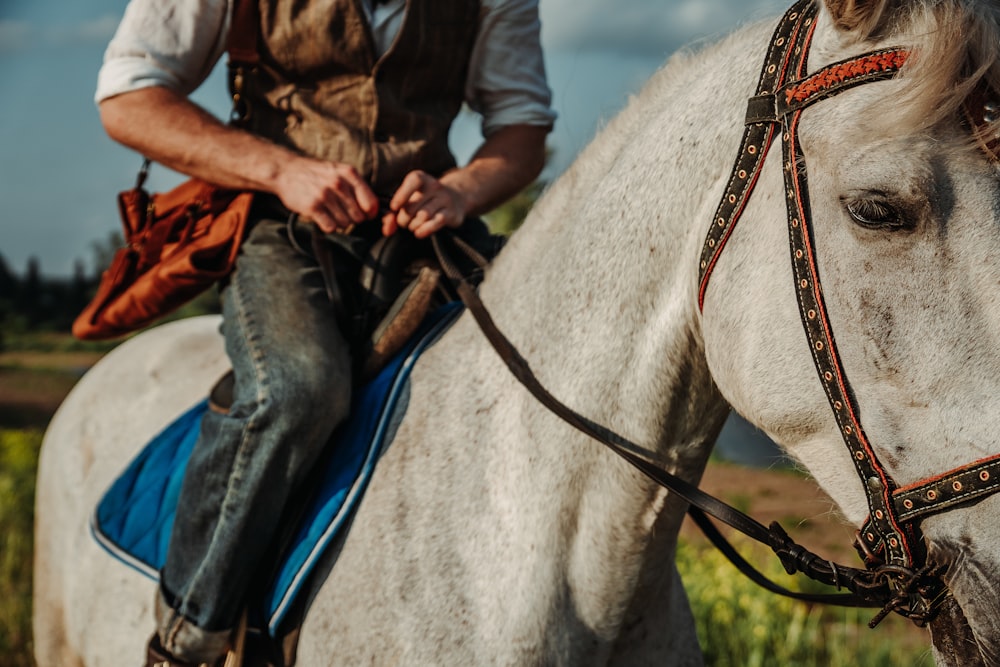 a man riding on the back of a white horse