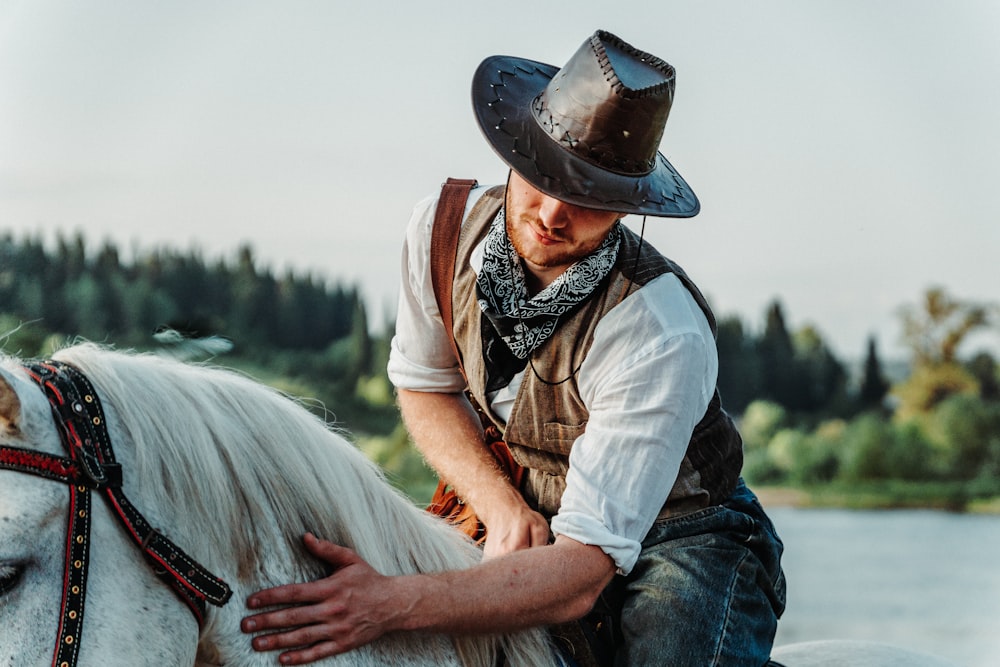 a man in a cowboy hat sitting on a white horse