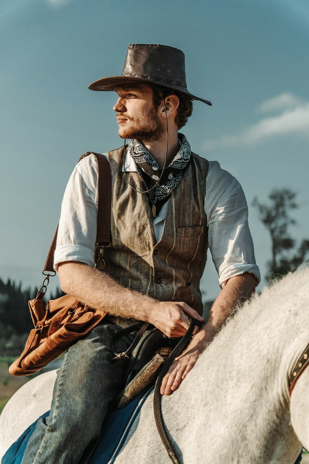 a man in a cowboy hat riding a white horse