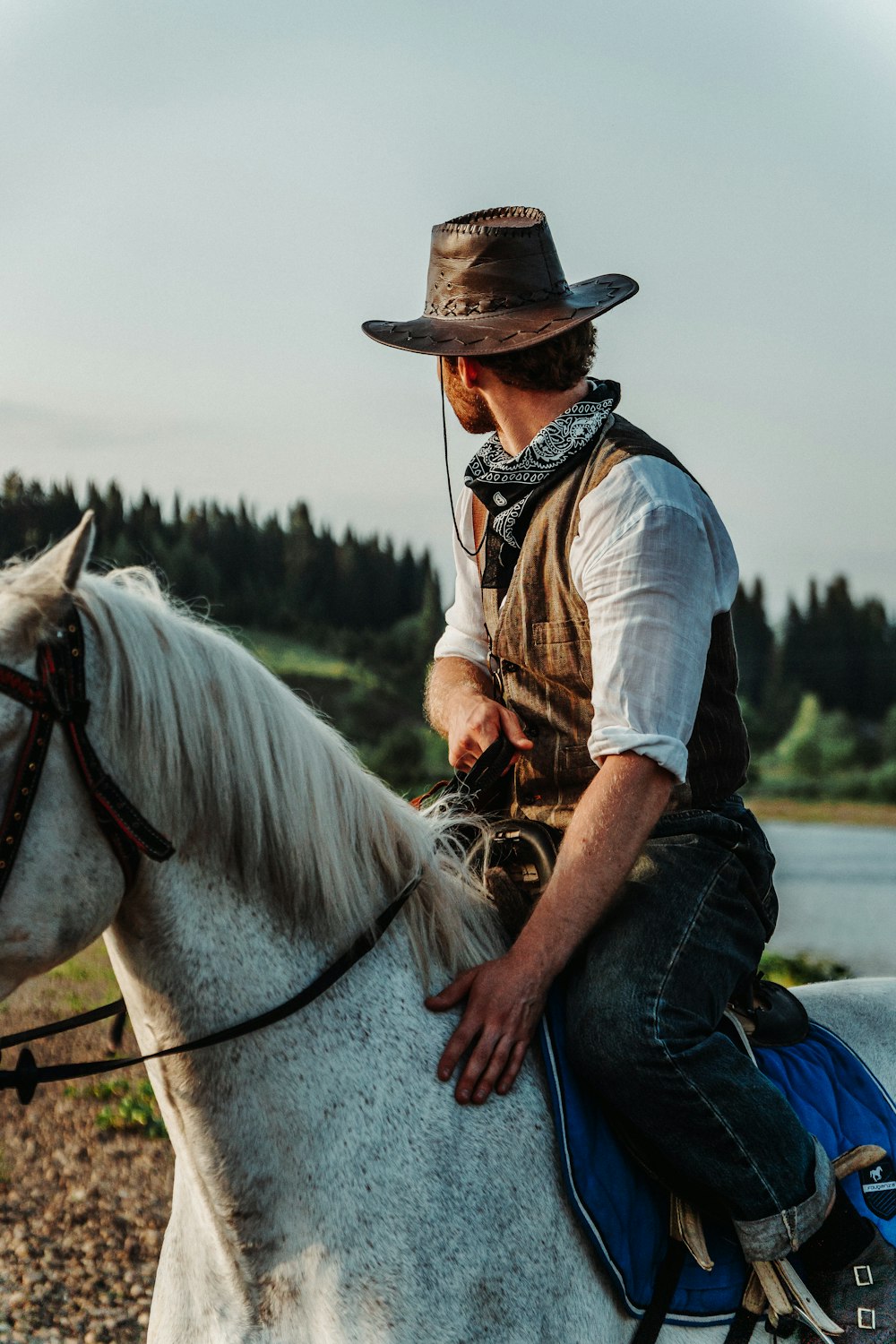 a man in a cowboy hat riding a white horse