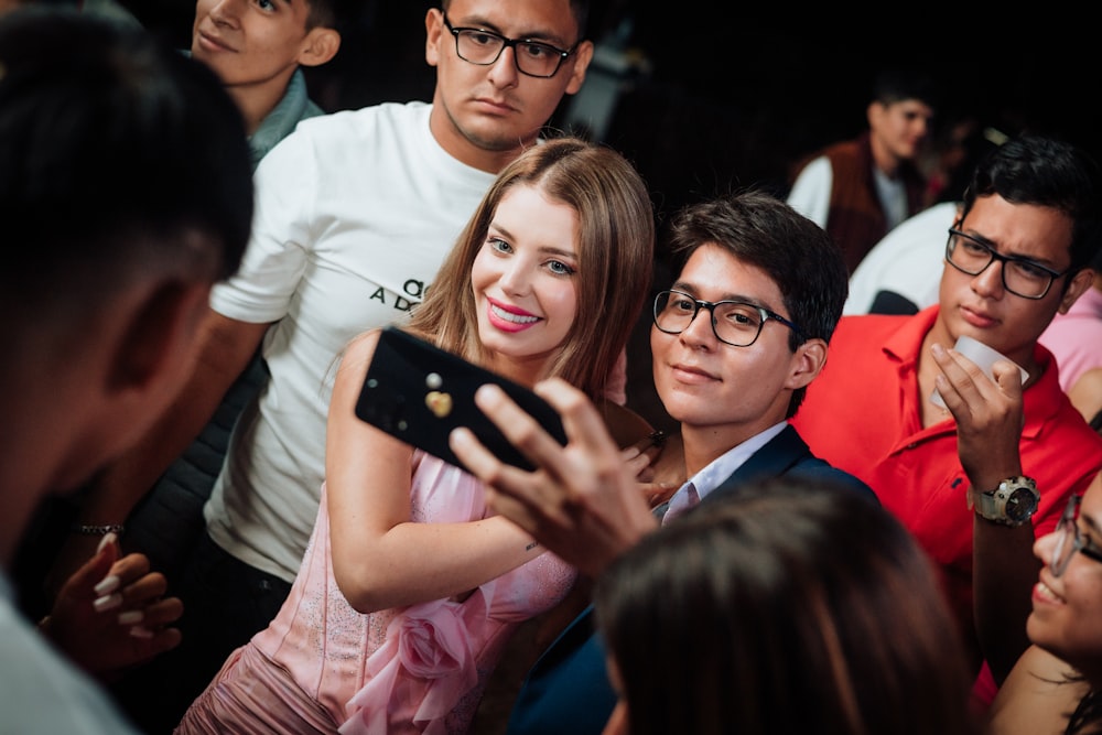 a group of people taking a picture with a cell phone