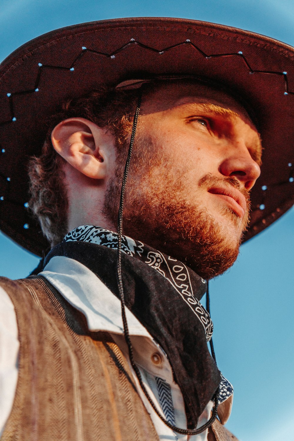 a man wearing a cowboy hat and a neck tie